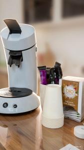 a white coffee maker on a table next to a box at Chez Marianne in Wailly +19 photos
