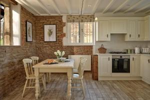 a kitchen with white cabinets and a table and chairs at South Lodge at Pudleston Court in Hatfield