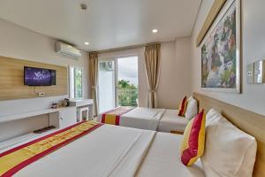 a hotel room with two beds and a tv at Summer Dream Hotel in Phú Quốc