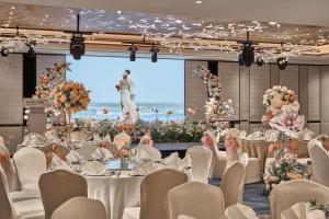 a banquet hall with tables and chairs and a stage with a presentation at Carlton Hotel Singapore in Singapore +55 photos