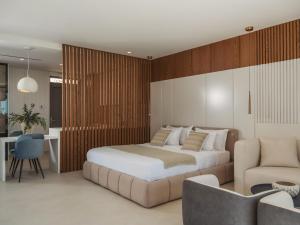 a bedroom with a king sized bed and a couch at Doci Kelios - Serenity Suites with Private Heated Pools, by ZanteWize in Agios Nikolaos