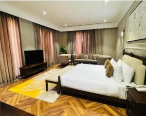 a large bedroom with a large bed and a television at The saffron anandamvillas in Kurukshetra