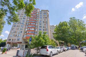 una strada cittadina con auto parcheggiate davanti a un edificio alto di Lake in Park a Chişinău