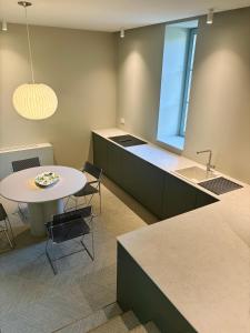 a kitchen with a table and a sink at Entre Pierres et Rivière - 2 Gites avec wellness privatifs in Hotton +36 photos