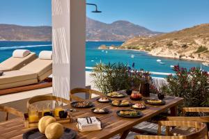 a table with food and a view of the ocean at Villa Soleil - Delmar Collection in Adamantas