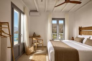 a bedroom with a bed and a large window at Villa Soleil - Delmar Collection in Adamantas +38 photos