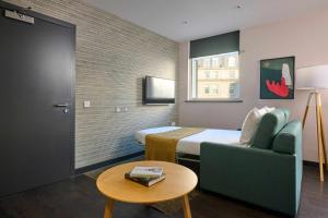 a hotel room with a bed and a couch and a table at COVE Cannon Street in London