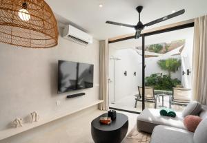a living room with a couch and a tv at The Arc House Canggu in Canggu
