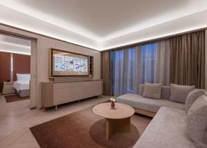 a living room with a couch and a tv at Orange Crystal Hotel Ningbo Ninghai in Ninghai