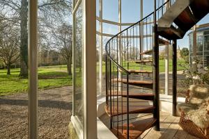 a glass house with a spiral staircase in front of a window at The Gatehouse at Pudleston Court in Hatfield