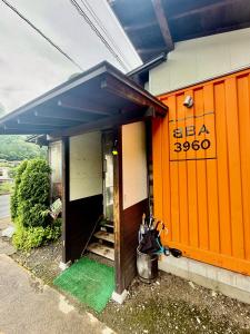 a house with an orange door and a porch at Takumisou1 in Kiso