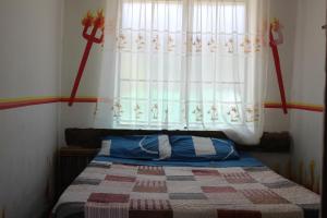 1 dormitorio con 1 cama y ventana con edredón en Hostería - Bodega Valle Divino, en Uriondo
