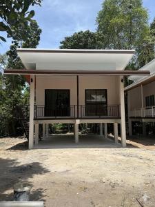 a small building with a porch and a balcony at The Summer Cozy Cottage in Haad Chao Phao