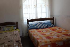 1 dormitorio con 2 camas y ventana en Hostería - Bodega Valle Divino, en Uriondo