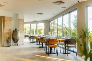 a restaurant with tables and chairs and large windows at Hotel Podstine in Hvar