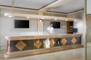 a man standing at a reception counter in a lobby at Hotel Festa Brava by ALEGRIA in Lloret de Mar +18 photos