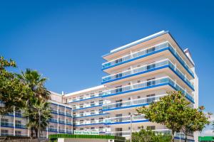 a tall white building with blue balconies at Hotel Festa Brava by ALEGRIA in Lloret de Mar