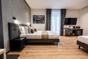 a hotel room with a bed and a television at Corso 84 Luxury Suites in Pescara