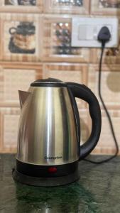 a tea kettle sitting on top of a counter at Awara Hostels and Dormitory in Lucknow