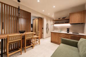 eine Küche und ein Wohnzimmer mit Tisch und Stühlen in der Unterkunft Mageiras Boutique Hotel in Afytos