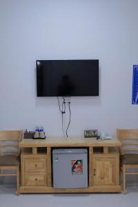 a flat screen tv on top of a wooden entertainment center at Happy Sun Hotel in Mỹ Tho +12 photos