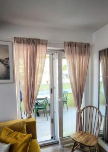 a living room with curtains and a couch and a patio at Maestral in Nerezine +15 photos