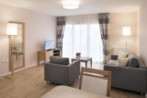 a living room with two chairs and a couch at DOMITYS – Le Carroussel in Cabourg +3 photos