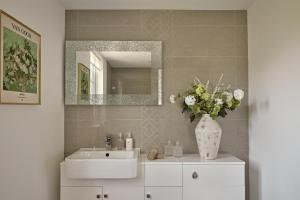 a bathroom with a sink and a vase of flowers at Ponds View at Pudleston Court in Docklow