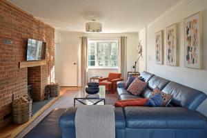 a living room with a blue couch and a brick wall at Ponds View at Pudleston Court in Docklow