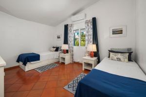 a bedroom with two beds and a window at Prainha Alvor - Cozy Villa in Alvor