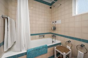 a bathroom with a tub and a shower at Prainha Alvor - Cozy Villa in Alvor +23 photos