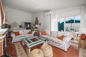 a living room with two couches and a table at Prainha Alvor - Cozy Villa in Alvor