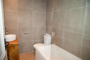 a bathroom with a tub and a toilet and a sink at The Devonshire Arms in Buxton