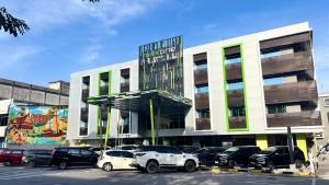 a parking lot with cars parked in front of a building at MAXONE Dumai in Dumai
