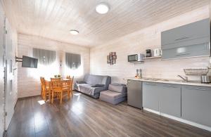a kitchen and living room with a couch and a table at Domki PoZdrowie in Rusinowo