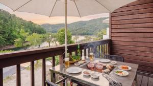 a table with food on a balcony with an umbrella at Pocheon Skygaram Pension in Pocheon +4 photos
