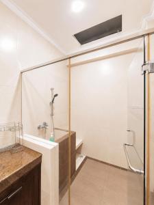 a bathroom with a shower with a glass door at Enny's Guest House in Malang +23 photos