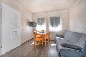a living room with a couch and a table at Domki PoZdrowie in Rusinowo +43 photos