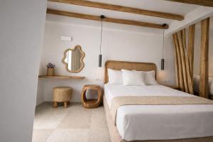 a bedroom with a bed and a mirror on the wall at REYA suites in Aliki