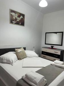 a bedroom with two beds and a tv on the wall at Vokopola Villa in Sarandë