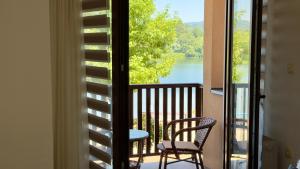 a balcony with a view of a lake and two chairs at Neo3 in Veliko Gradište