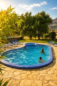 a group of people swimming in a swimming pool at Complex Rural Can Caubet in Berga