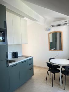 a kitchen with blue cabinets and a table and chairs at Apartman Kalac in Korčula