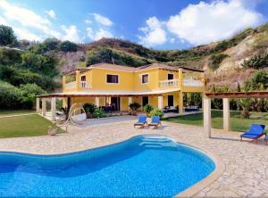 a villa with a swimming pool in front of a house at Villa Alexandros in Spartià