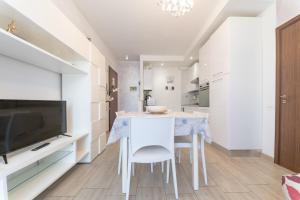 a kitchen with a table and chairs and a television at VIOLA CON SERVIZIO SPIAGGIA - LIDO ADRIANO in Lido Adriano
