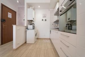 a kitchen with white cabinets and a washer and dryer at VIOLA CON SERVIZIO SPIAGGIA - LIDO ADRIANO in Lido Adriano +32 photos
