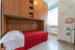 a bedroom with a red bed and a wooden wall at VIOLA CON SERVIZIO SPIAGGIA - LIDO ADRIANO in Lido Adriano