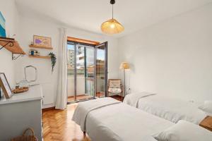 a bedroom with two beds and a window with a view at Driftwood - Refúgio Perto do Mar in Matosinhos