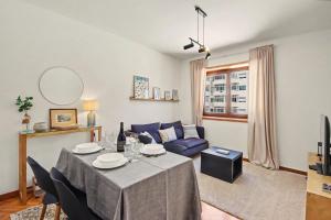 a living room with a table and a blue couch at Driftwood - Refúgio Perto do Mar in Matosinhos