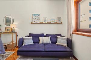 a purple couch in a living room with a mirror at Driftwood - Refúgio Perto do Mar in Matosinhos